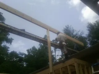 Carpenter setting a ridge beam over a new addition frame — Ice Dam Removal by Roofing Brothers in Hastings